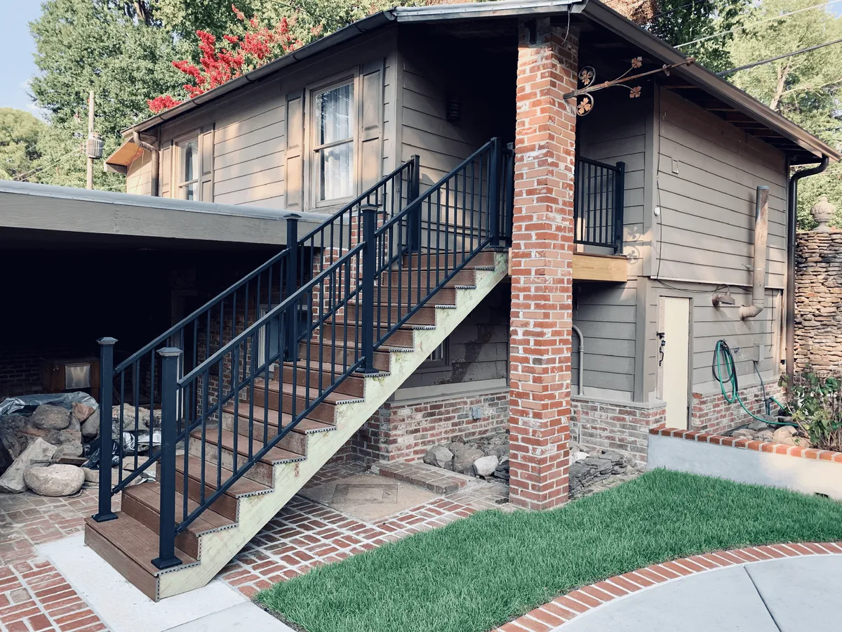 The estate’s outdoor staircase and brick column, bordered by landscaped gardens. The inviting steps and greenery hint at social gatherings and peaceful strolls, embodying a sense of place and historic character.